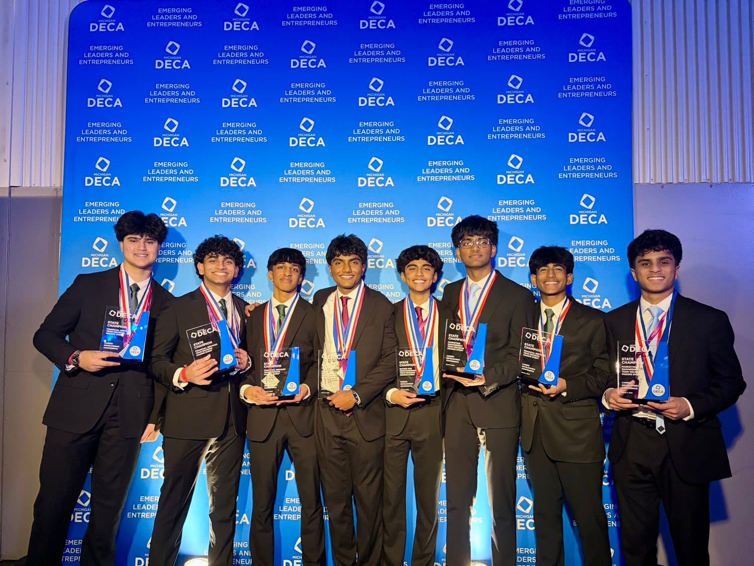 Novi DECA members holding their state championship trophies